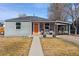 Charming gray home featuring an inviting front porch and well-maintained front yard at 6835 W 55Th Pl, Arvada, CO 80002