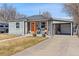 Charming gray home featuring an inviting front porch and a carport at 6835 W 55Th Pl, Arvada, CO 80002