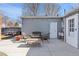 Cozy back patio with a gray house exterior, string lights, an outdoor seating area, and concrete pavers at 6835 W 55Th Pl, Arvada, CO 80002