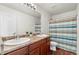 Well-lit bathroom features a double vanity with modern fixtures and a shower with a striped curtain at 11187 Carbondale St, Firestone, CO 80504