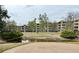 An apartment complex with a fenced in pond, green space, and mature trees at 1302 S Parker Rd # 316, Denver, CO 80231