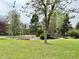Expansive green grounds with mature trees, grass, and a wooden bridge at 1302 S Parker Rd # 316, Denver, CO 80231