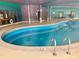Indoor pool with handrails, deck, and a surrounding painted turquoise and purple wall at 1302 S Parker Rd # 316, Denver, CO 80231