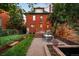 Landscaped backyard with a garden, brick patio, and outdoor seating areas at 1256 N Emerson St, Denver, CO 80218