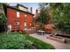Spacious backyard featuring a brick patio, garden beds, and mature trees at 1256 N Emerson St, Denver, CO 80218