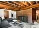 Inviting basement featuring exposed brick, modern furniture, and a stylish coffee table at 1256 N Emerson St, Denver, CO 80218
