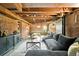 Finished basement with exposed brick walls, industrial-style ceiling, and comfortable seating area at 1256 N Emerson St, Denver, CO 80218