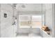 Elegant white marble bathroom featuring a glass shower enclosure and a bright window at 1256 N Emerson St, Denver, CO 80218