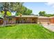 Well-kept backyard featuring a covered patio and a well-manicured lawn at 3925 Newland St, Wheat Ridge, CO 80033