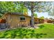 Large backyard shows the home's patio, large shade tree, and expansive green space at 3925 Newland St, Wheat Ridge, CO 80033