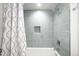 Bathroom featuring light blue subway tile in shower area, decorative curtain, and niche in shower wall at 3925 Newland St, Wheat Ridge, CO 80033