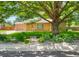 Inviting front exterior features a well-manicured lawn, mature shade tree, and brick facade at 3925 Newland St, Wheat Ridge, CO 80033