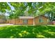Charming brick home featuring a bright yellow door, attached garage, and lush front lawn at 3925 Newland St, Wheat Ridge, CO 80033