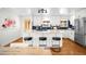 Updated kitchen boasts white cabinets, backsplash, and center island with barstool seating at 3925 Newland St, Wheat Ridge, CO 80033