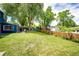 Expansive backyard featuring a lush lawn, mature trees, a privacy fence, and a storage shed at 4645 W Temple Pl, Denver, CO 80236