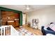 Cozy Bedroom with wood accent wall, wood floors and changing station at 4645 W Temple Pl, Denver, CO 80236
