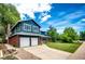 A blue two-story home features a two-car garage, brick accents, and a well-maintained lawn at 4645 W Temple Pl, Denver, CO 80236