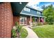 Inviting front porch with brick siding, American flag, and garden filled with colorful flowers at 4645 W Temple Pl, Denver, CO 80236