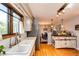 Spacious kitchen with bright white countertops, hardwood floors, stainless steel fridge, and a view to the dining area at 4645 W Temple Pl, Denver, CO 80236