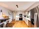 Bright kitchen features wood floors, white cabinets, stainless steel appliances, and modern lighting at 4645 W Temple Pl, Denver, CO 80236