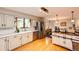 Open kitchen with stainless steel appliances, custom island, hardwood floors, and ample counter space at 4645 W Temple Pl, Denver, CO 80236