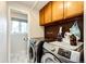 Functional laundry room with modern washer and dryer units, storage cabinets, and natural light at 4645 W Temple Pl, Denver, CO 80236