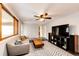 Spacious living room featuring a ceiling fan, a modern entertainment center, and large picture windows at 4645 W Temple Pl, Denver, CO 80236