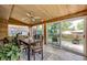 Enclosed sunroom with wood paneling, tile flooring, and sliding glass doors leading to the backyard at 4645 W Temple Pl, Denver, CO 80236