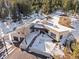 Breathtaking aerial view showcasing architectural design of the property, surrounded by snow covered land at 1053 Red Moon Rd, Evergreen, CO 80439