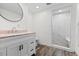 Bathroom featuring walk-in shower with marble-look tile, wood-look tile floor, and single vanity sink at 1053 Red Moon Rd, Evergreen, CO 80439