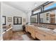 Bathroom featuring dual sinks, natural light, ceramic tile countertop, and a large soaking tub at 1053 Red Moon Rd, Evergreen, CO 80439