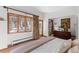 Sun-filled bedroom featuring wood-look tile floor, exterior view, and neutral wall paint at 1053 Red Moon Rd, Evergreen, CO 80439