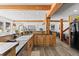 An open kitchen features wood cabinets, beams, wood-look flooring, stone countertops, and stainless appliances at 1053 Red Moon Rd, Evergreen, CO 80439