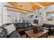 Bright living room with vaulted wood ceiling, fireplace, large windows, and a comfortable leather sofa at 1053 Red Moon Rd, Evergreen, CO 80439