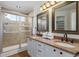 Bathroom with double vanity, granite countertop, and shower at 9488 Brook Ln, Lone Tree, CO 80124