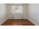 Empty bedroom featuring wood flooring and a window at 9488 Brook Ln, Lone Tree, CO 80124