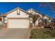 Beige house with a two-car garage and a wooden deck at 9488 Brook Ln, Lone Tree, CO 80124