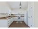 Bright eat-in kitchen with white cabinets, laminate counters, and modern appliances at 9488 Brook Ln, Lone Tree, CO 80124