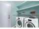 Laundry room with washer, dryer, and shelving at 9488 Brook Ln, Lone Tree, CO 80124