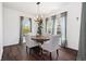 Bright dining room with a wood table set for four, light-colored chairs, and modern chandelier at 10938 Mcclellan Rd, Parker, CO 80134