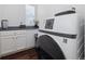 Modern laundry room featuring gray countertops, sleek white cabinets, and a high-efficiency washer and dryer set at 10938 Mcclellan Rd, Parker, CO 80134