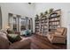 Cozy living room featuring a bookcase with library ladder, hardwood floors and neutral tones at 10938 Mcclellan Rd, Parker, CO 80134