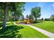 Community playground on a sunny day, with green grass and trees at 10938 Mcclellan Rd, Parker, CO 80134