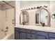 Bathroom featuring double sink vanity, shower over bath, and decorative mirrors at 2575 S Syracuse Way # H106, Denver, CO 80231