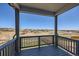 Covered balcony with gray wood and a scenic view of the rolling hills in the background at 6646 Merrimack Dr, Castle Pines, CO 80108