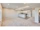 Open finished basement area with kitchenette, carpet, and neutral walls at 6646 Merrimack Dr, Castle Pines, CO 80108