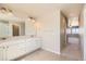 Well-lit bathroom features a dual sink vanity with white cabinets and tile flooring at 6646 Merrimack Dr, Castle Pines, CO 80108
