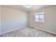 Clean carpeted bedroom with neutral walls and a bright window showing the exterior at 6646 Merrimack Dr, Castle Pines, CO 80108