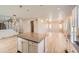 Open layout with kitchen island, stainless appliances, wood floors, and ample natural light at 6646 Merrimack Dr, Castle Pines, CO 80108