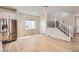 Inviting room with wood floors, stainless fridge, staircase, and modern chandelier at 6646 Merrimack Dr, Castle Pines, CO 80108